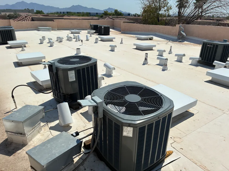 A flat commercial roof in Phoenix with rooftop HVAC units, vents and parapet walls