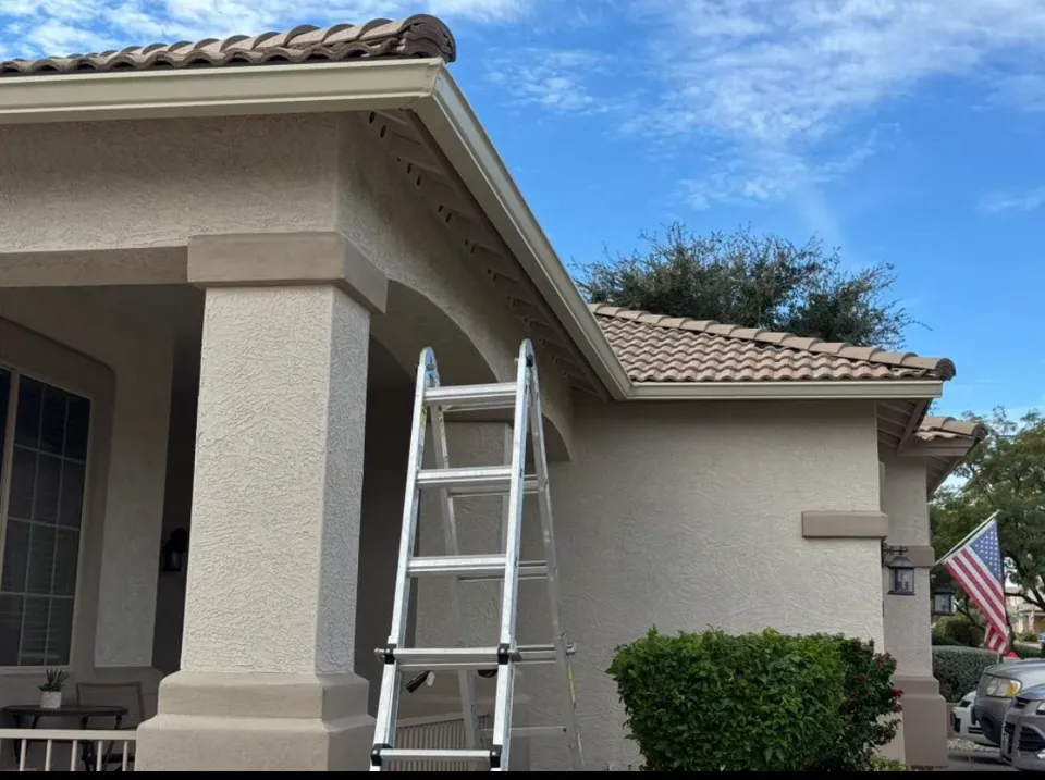 Seamless gutter installation in progress on a tile-roof entry in Phoenix