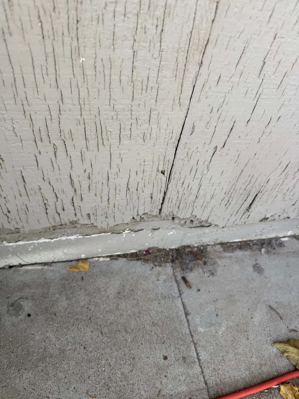 Water staining at the base of a stucco wall on a home with no gutters