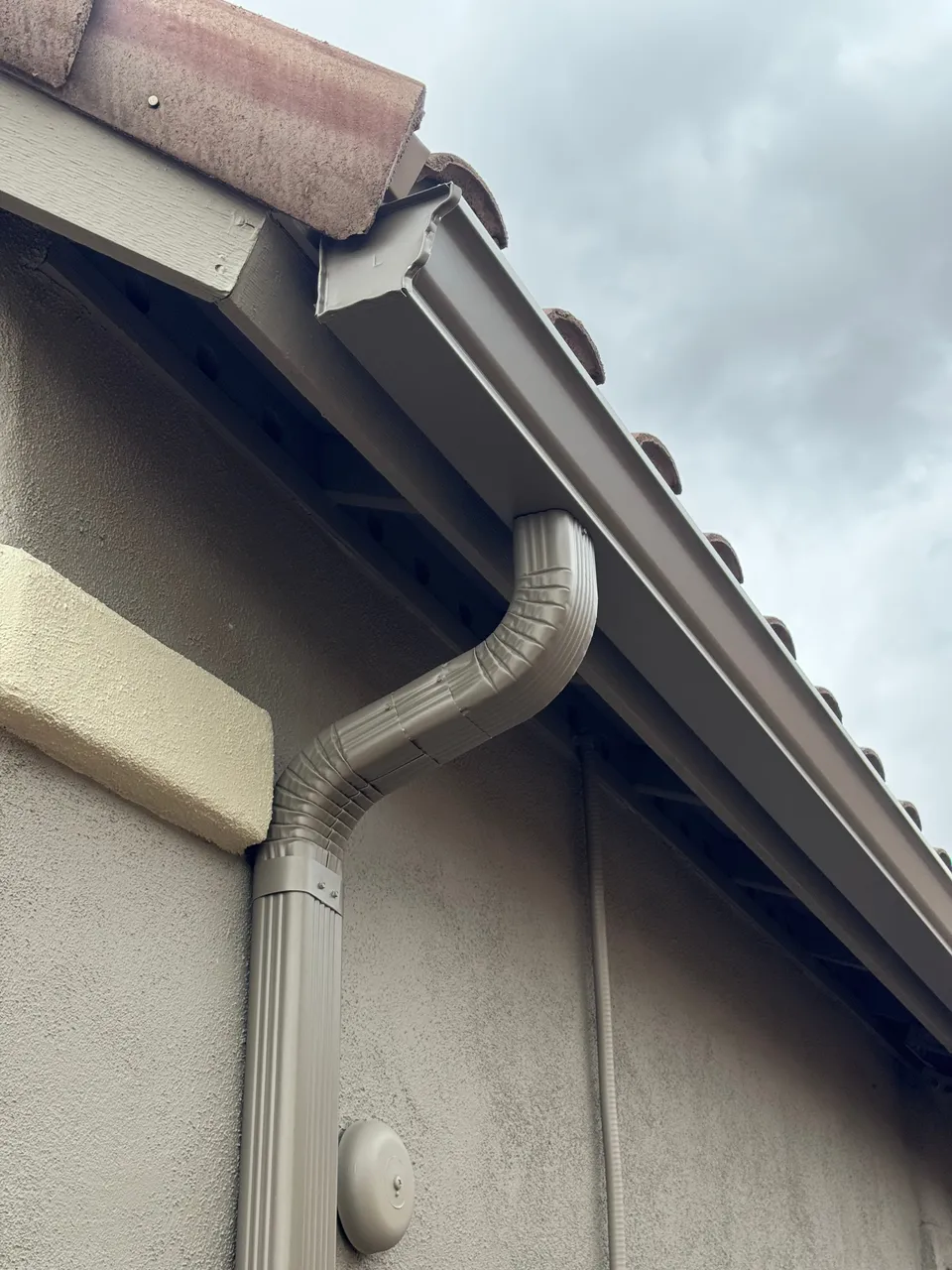Tan seamless gutter and downspout on a Phoenix tile roof